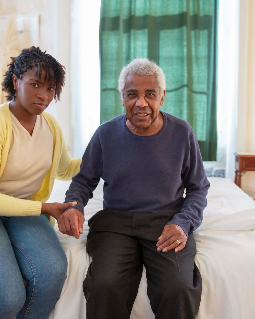 A Keana Care support worker sitting and talking with an older man in his own home